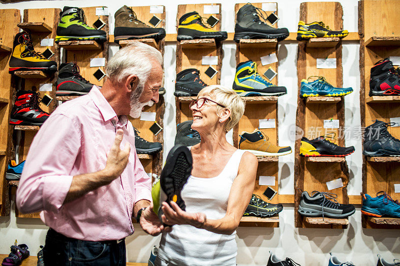 一对相爱的老夫妇在户外活动商店里购买攀岩鞋