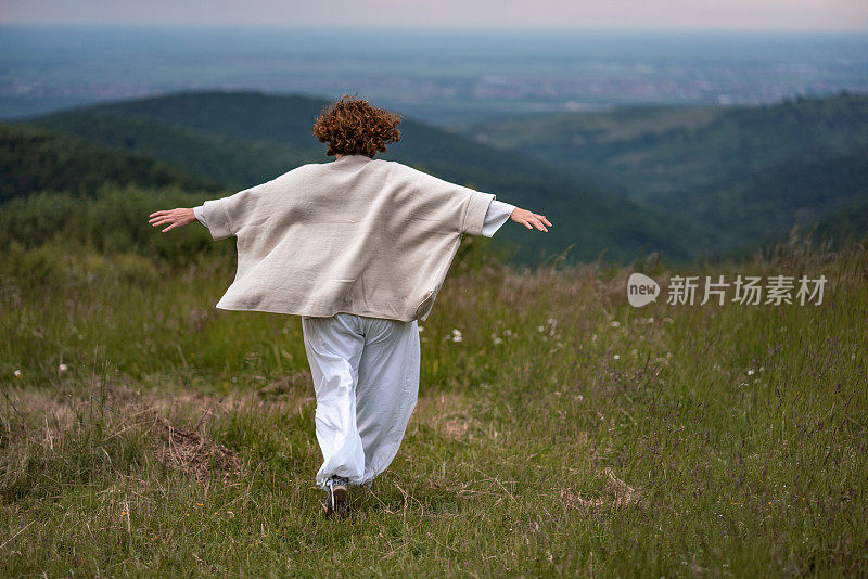 在大自然中伸出双臂的女人