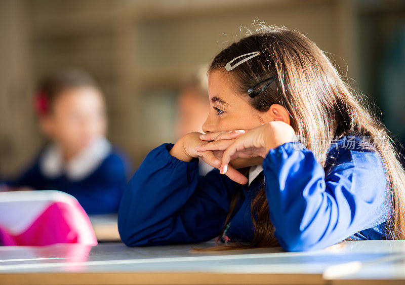 回到学校。教育的概念。沉思的小学女孩坐在课桌前上课的肖像