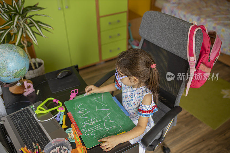 一个学前班的女孩在家里学习写字