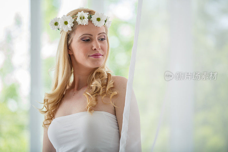 美丽的新娘戴着花冠，在梦想着她的大喜日子