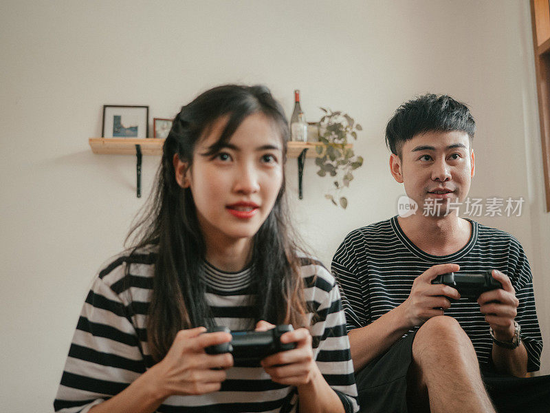 新冠肺炎期间，年轻夫妇在家玩电子游戏