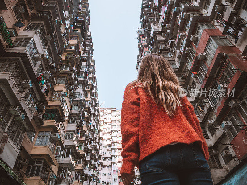 香港，一名女子抬头看着拥挤的公寓