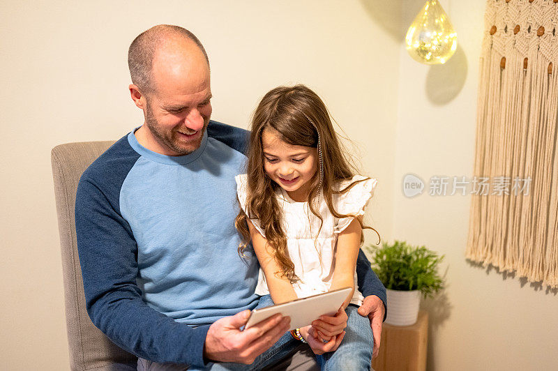女儿和父亲一起使用科技产品