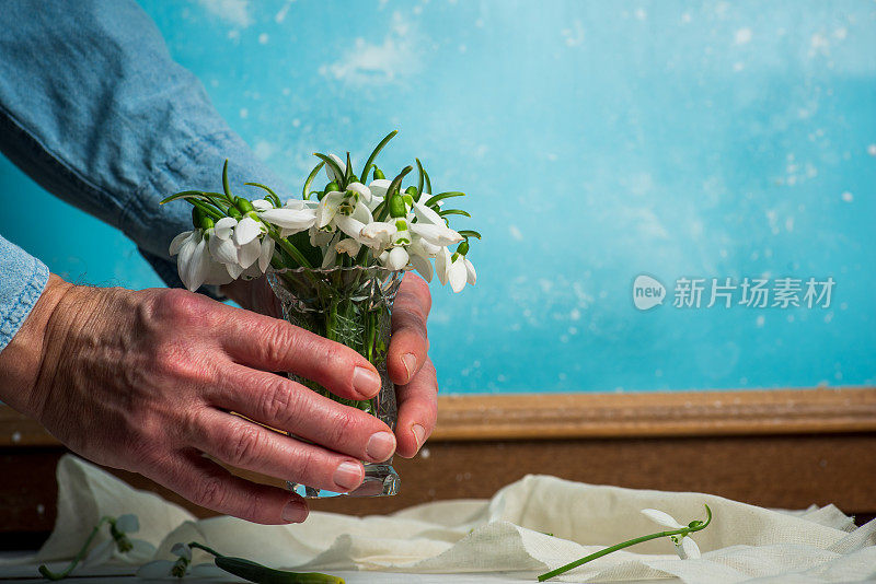 男人捧着雪花莲花束