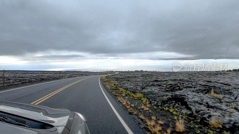 POV沿着汽车行驶在开阔的道路上，熔岩床