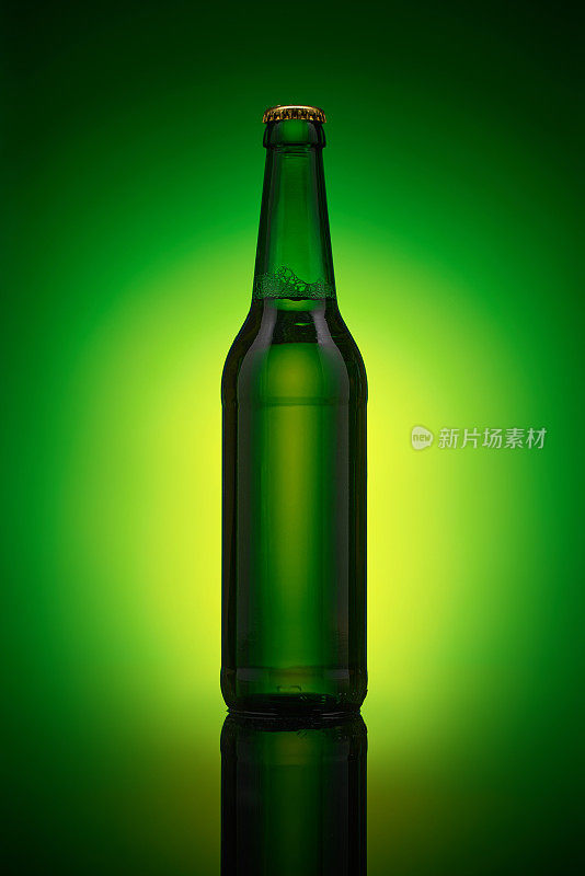 绿色啤酒瓶立在镜面上。