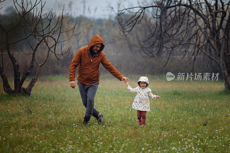 父亲和女儿在雨中漫步