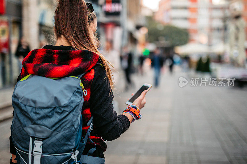 女游客正在手机上查看城市地图