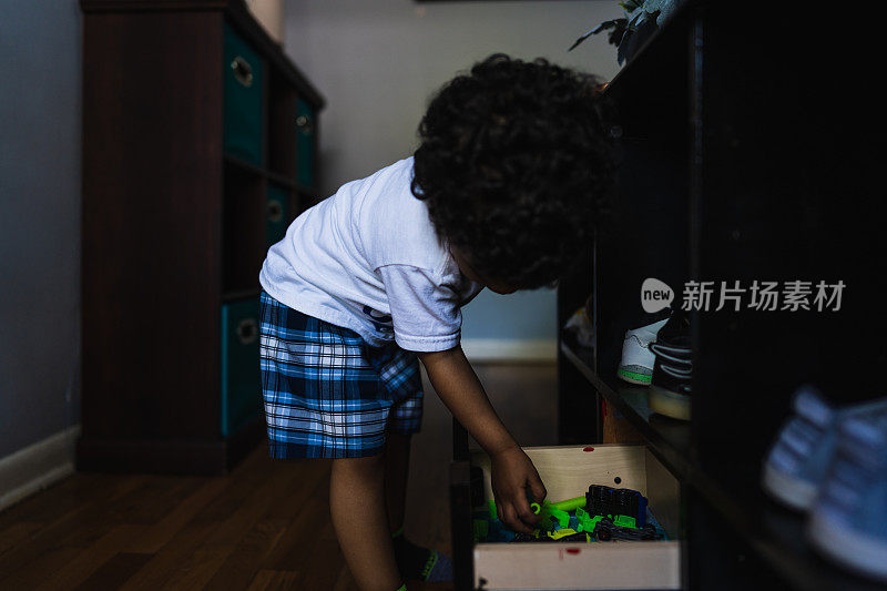 小男孩在卧室里的玩具盒里找玩具