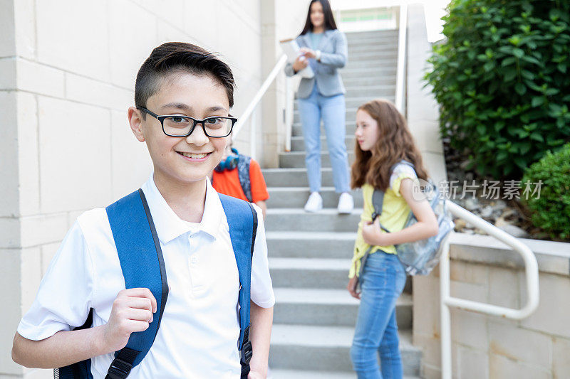 一名中学生背着书包在学校户外微笑