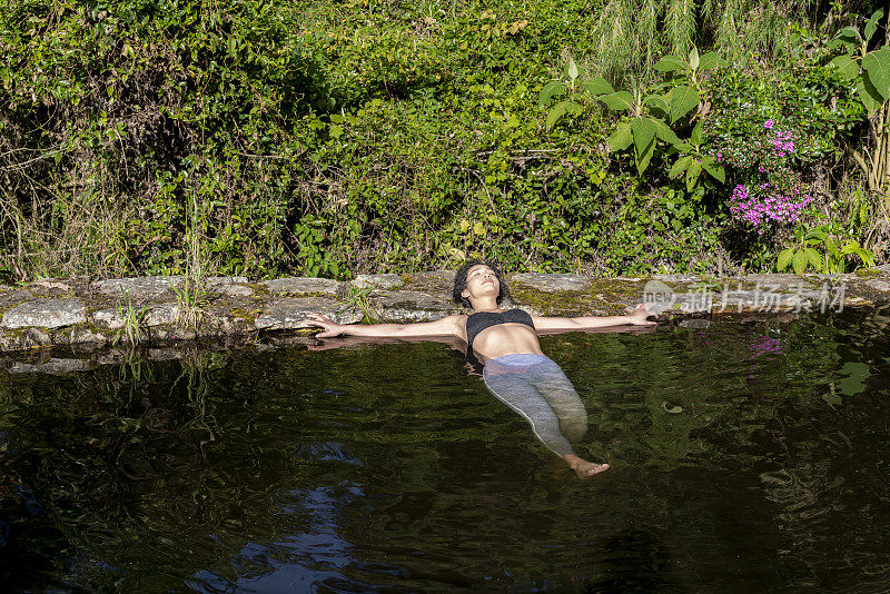 一个拉丁女子在湖中浸泡着她的身体享受大自然