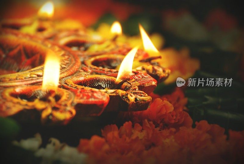 印度节日排灯节，Navratri，庆祝活动的垂直图片点燃彩色的Diya灯与万寿菊花和绿叶