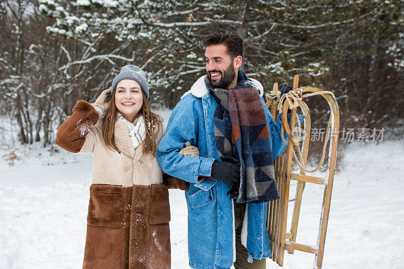 这对年轻夫妇喜欢在雪地和雪橇上享受冬季魔法