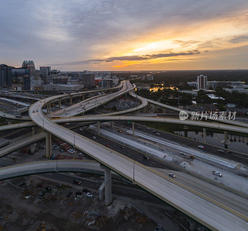 大型交通枢纽前的住宅区，有高速公路和多个立交桥，在清晨的日出中，可以看到奥兰多市中心的远处景色。超大，高分辨率的拼接全景图。