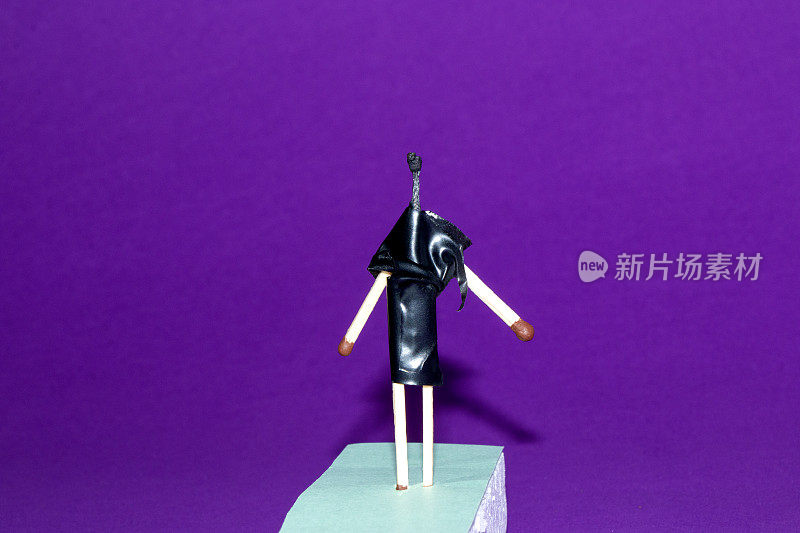 烧过的火柴插在黑色丝带创意概念时装秀上，搭配模特在紫色背景下黑发走秀