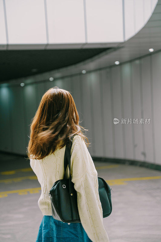 一个亚洲女孩在下午独自在隧道里回家