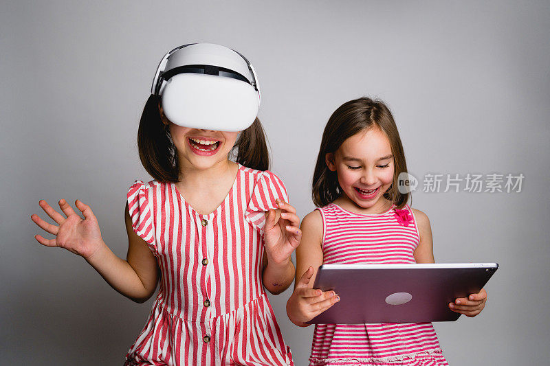 女孩们用数字平板电脑和VR头盔玩得很开心