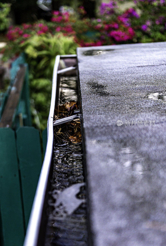 在暴风雨中，一个普通家庭屋顶上的雨槽