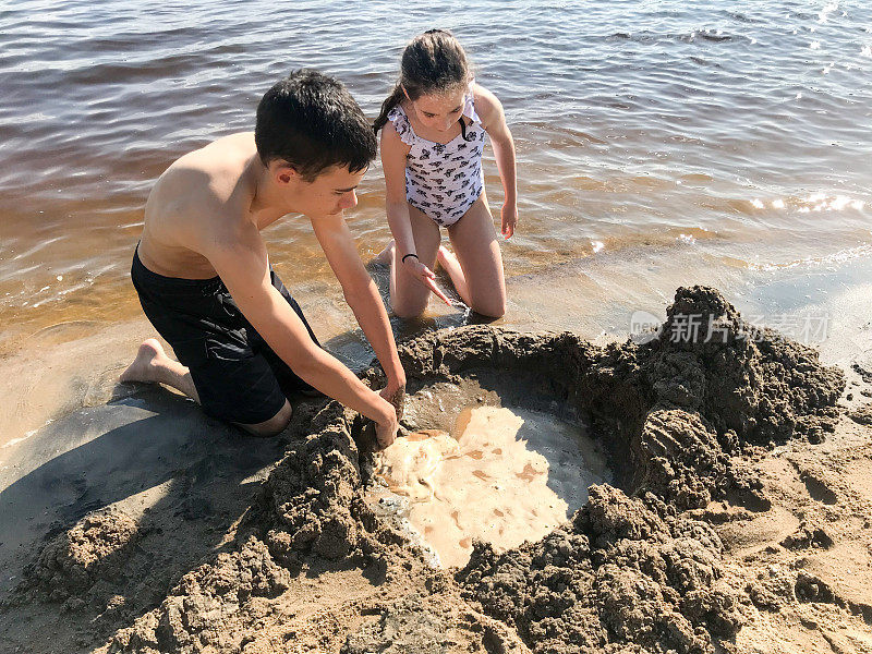 哥哥和姐姐在堆城堡的沙子
