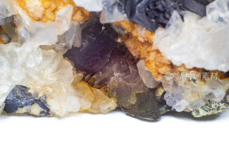 一个水晶和石团与清晰的白色石英，银色金属黄铁矿和黑色碧玺包围的基质宏观近距离隔离在一个白色的表面背景