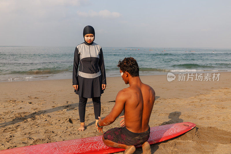 印尼男冲浪教练教穆斯林女子用冲浪板冲浪
