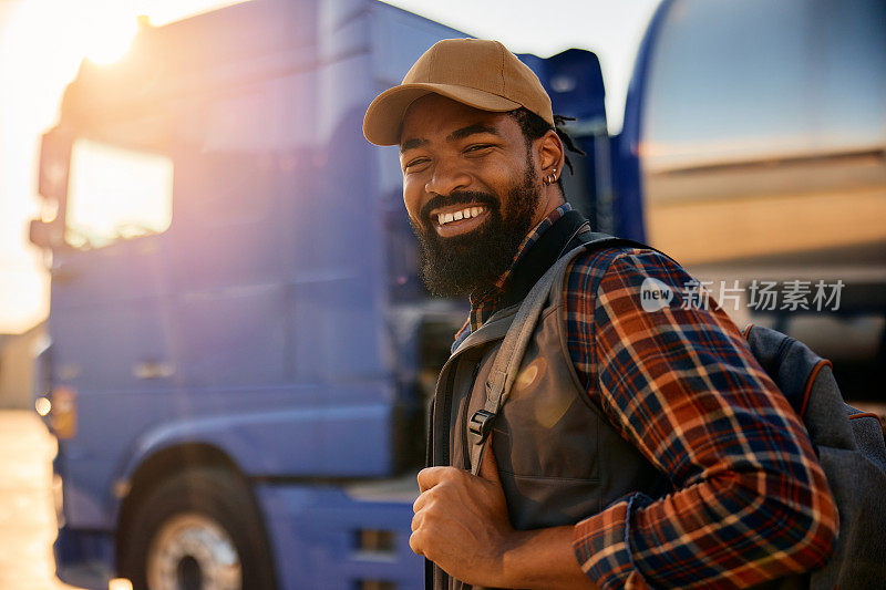快乐的非裔美国卡车司机看着镜头。