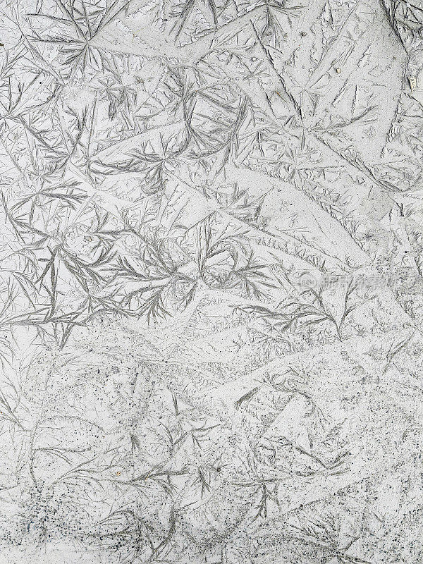 晶莹剔透的霜冻纹理自然冰块在灰色色调的冷色调，孤立的黑色背景。