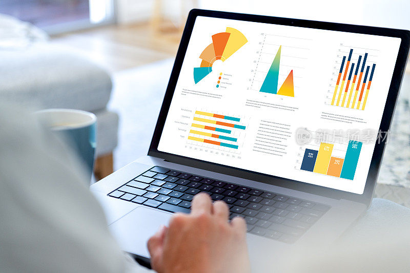 在家用电脑处理金融数据的人。笔记本电脑显示图表和图形