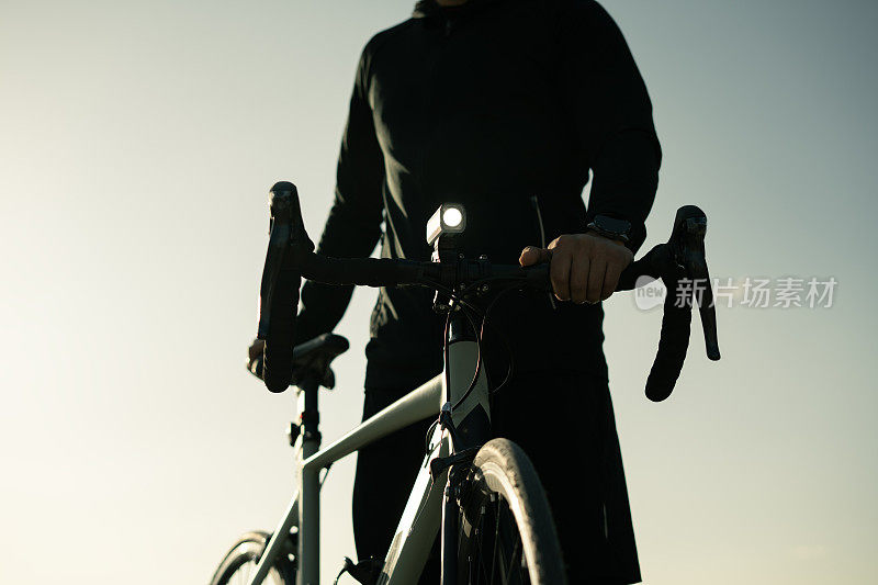 专业自行车手在日落时观看风景
