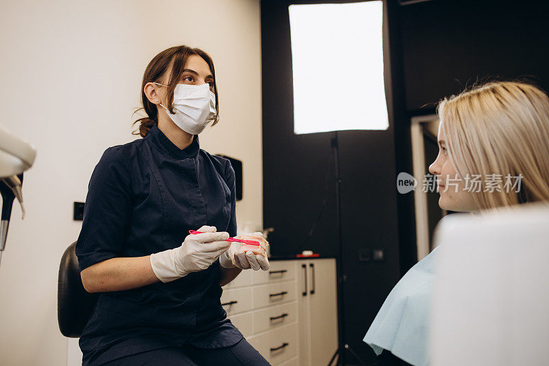 牙医和病人在会诊时选择治疗方案，后台有医疗设备