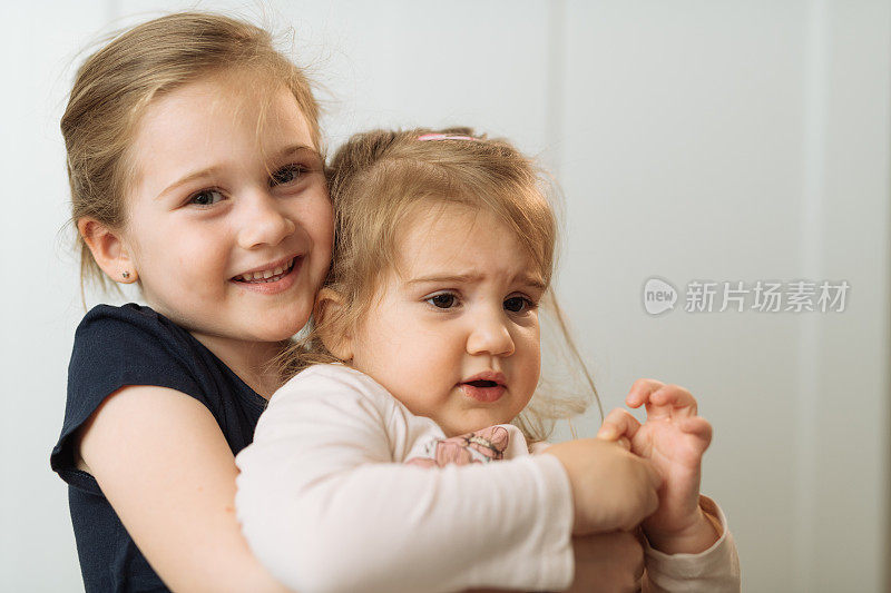 五岁小女孩拥抱小妹妹的肖像