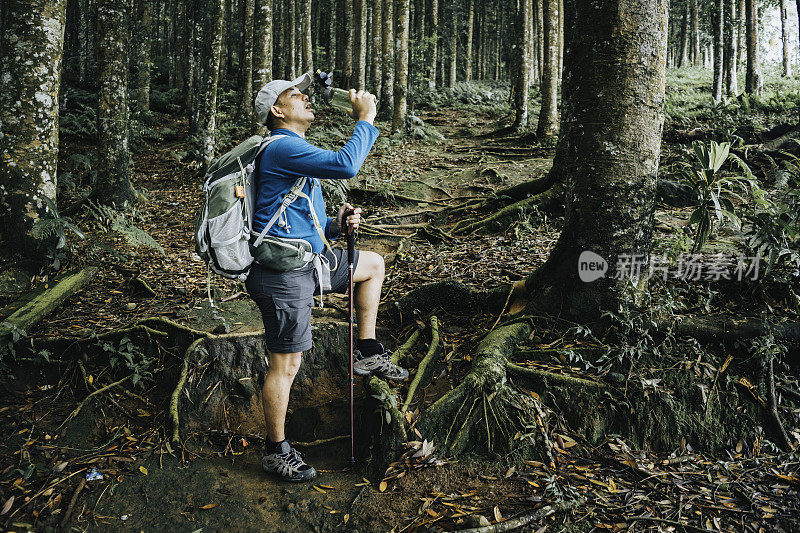 亚洲人在森林里追踪时喝淡水