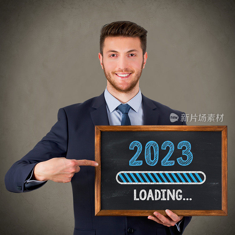 在黑板背景上加载2023年新年的商人绘图