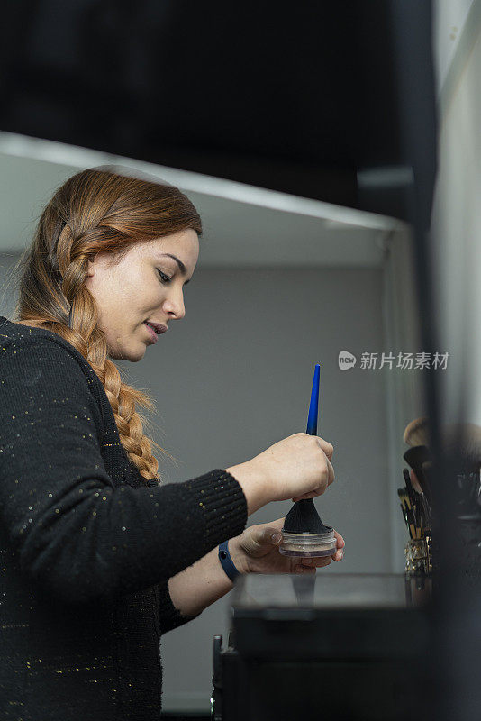 一名拉丁裔女子在化妆室的镜子前自己化妆