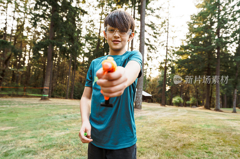小男孩用玩具枪对准摄像机