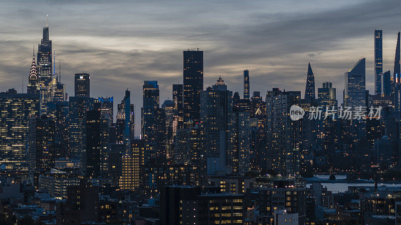 长岛市住宅区和猎人角豪华公寓。曼哈顿中城在东河上可见克莱斯勒大厦，范德比尔特广场一号在夜间照明。