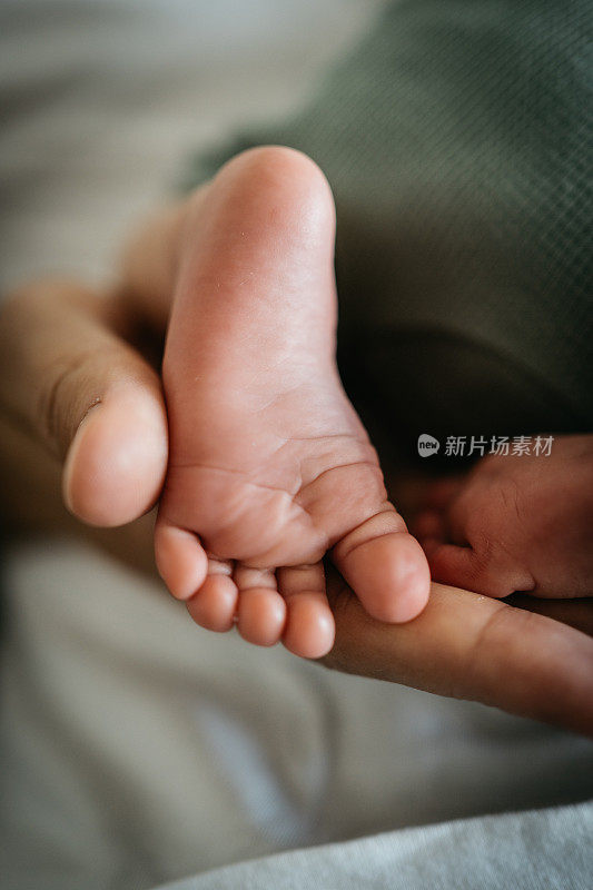 宝宝的脚被妈妈抱着