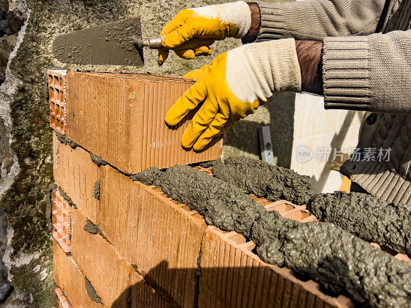 有经验的砌砖工人用泥铲砌砖