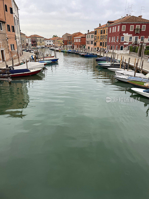 意大利威尼斯穆拉诺岛威尼斯泻湖上的运河图像，色彩缤纷的建筑，停泊的船只，从桥上看水路，缩小视角，聚焦于前景