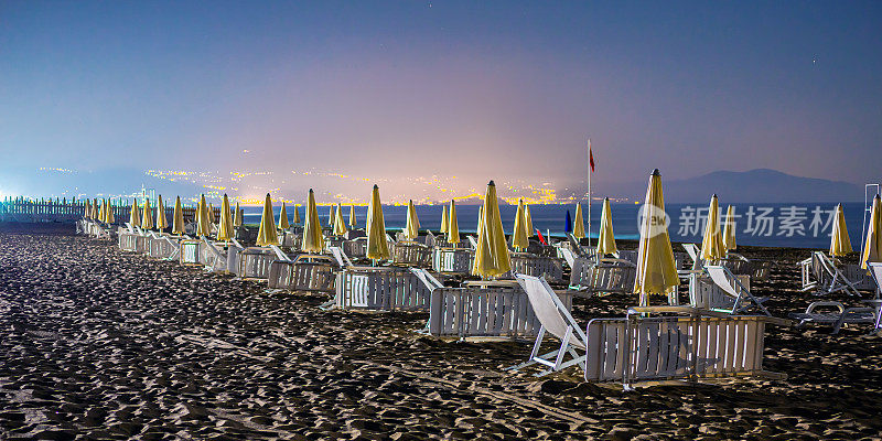 夜景，有躺椅和海边的沙滩伞。Agropoli。意大利。第勒尼安海。海滩。星星