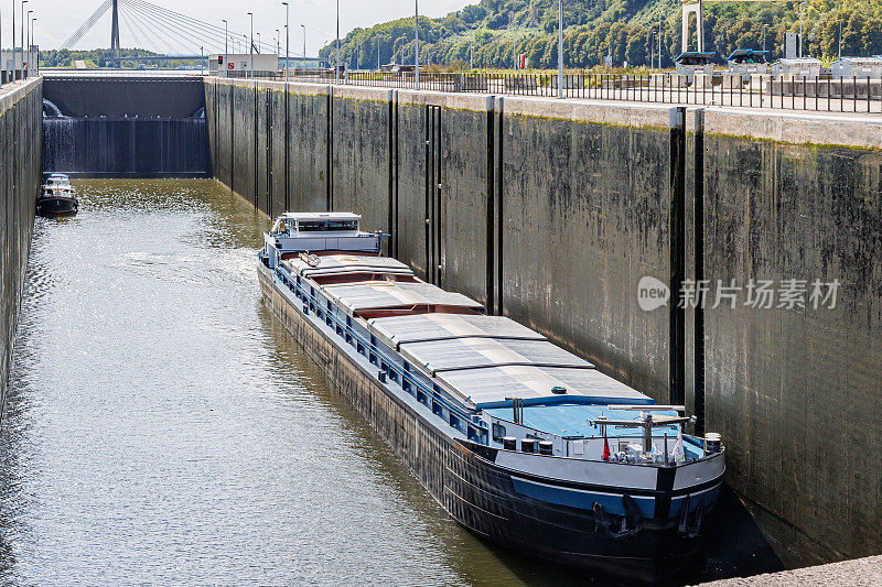 货船和小船在Lanaye水闸，在低水位的巨大墙壁之间