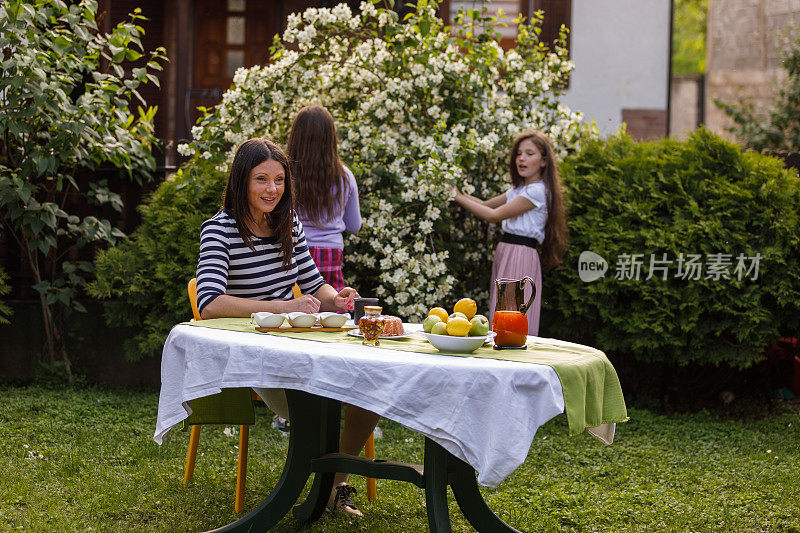 一位女士在她的花园里享用下午咖啡