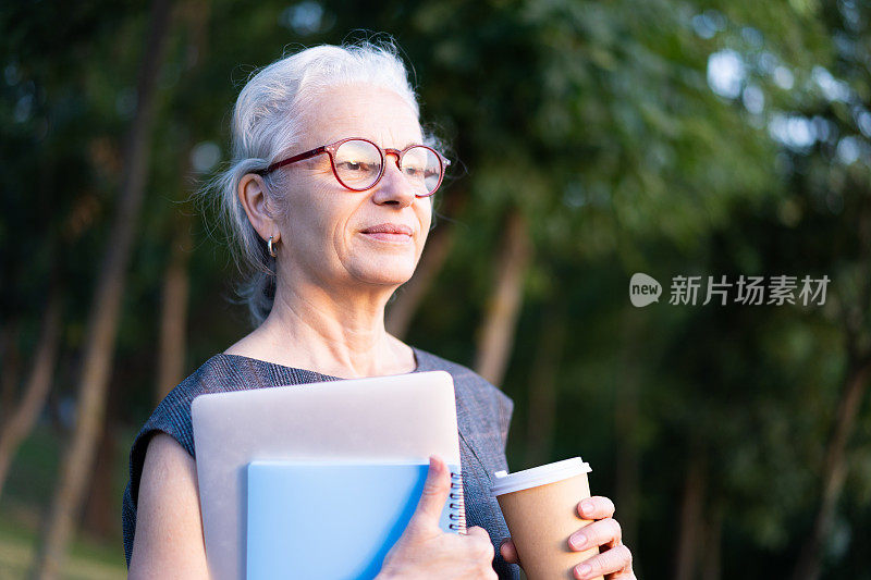 西班牙资深商务女士的肖像，灰白头发，复古眼镜，喝着咖啡。老太太拿着笔记本，蓝色笔记本和咖啡杯