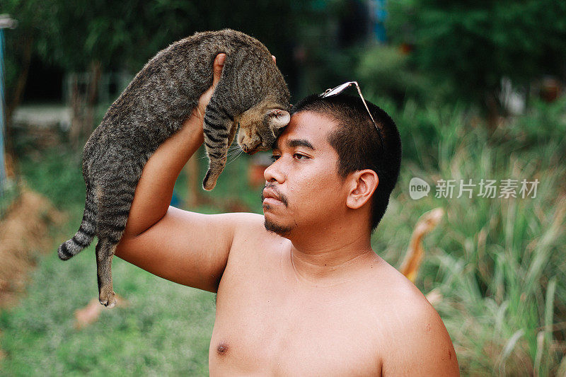 棕色皮肤的男人在和猫玩