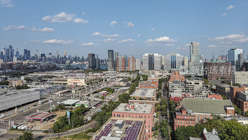 曼哈顿市中心的天际线沿着新泽西州泽西城社区延伸。通往哈德逊河滨水区的商业区街道