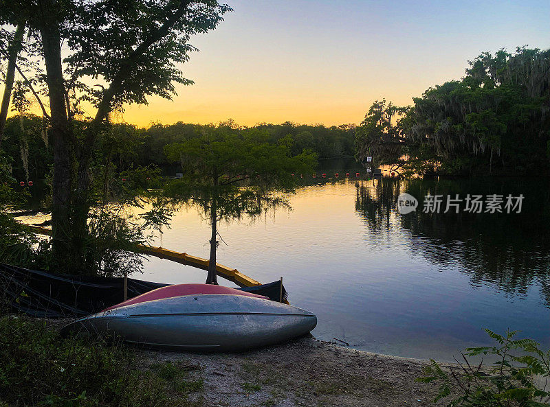 田园诗般的日落在蓝泉州立公园在奥兰治市佛罗里达州，美国与皮划艇和独木舟在前景