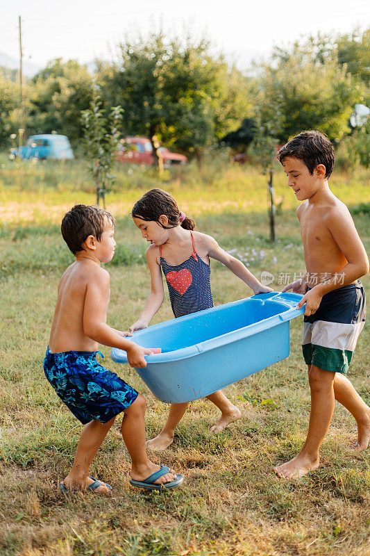 炎热的夏日，孩子们在院子里打水仗