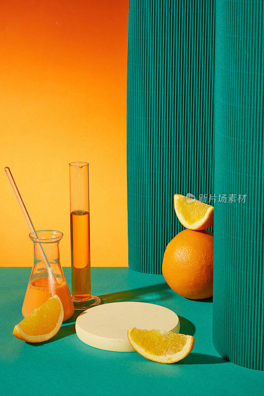 新鲜的橘子和柑橘汁，蓝色背景的实验室眼镜，圆形的白色讲台用于展示产品。广告照片与复制空间