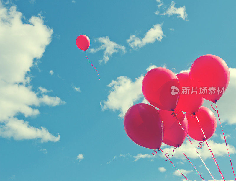 蓝色天空上的一堆红色气球